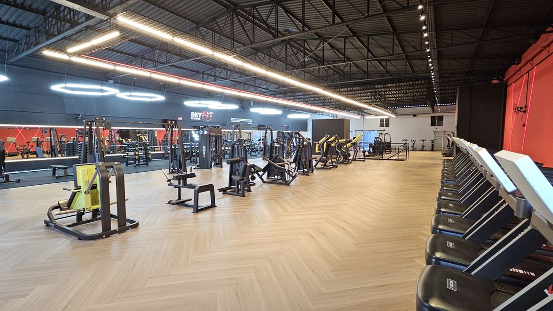 Interior de galpão comercial com estrutura metálica aparente, reformado pela Vallim para receber uma academia